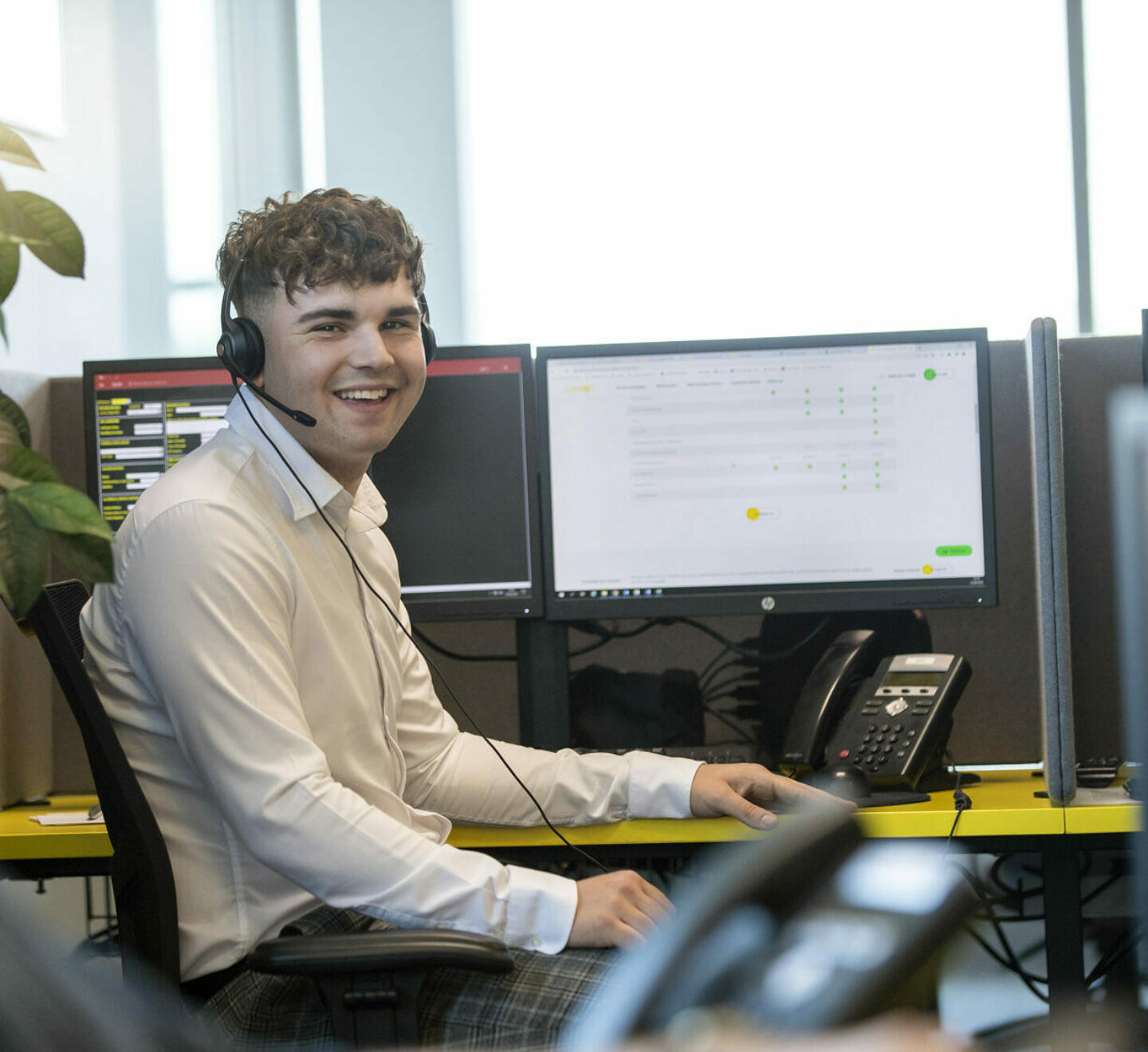 Male contact centre operator smiling at camera