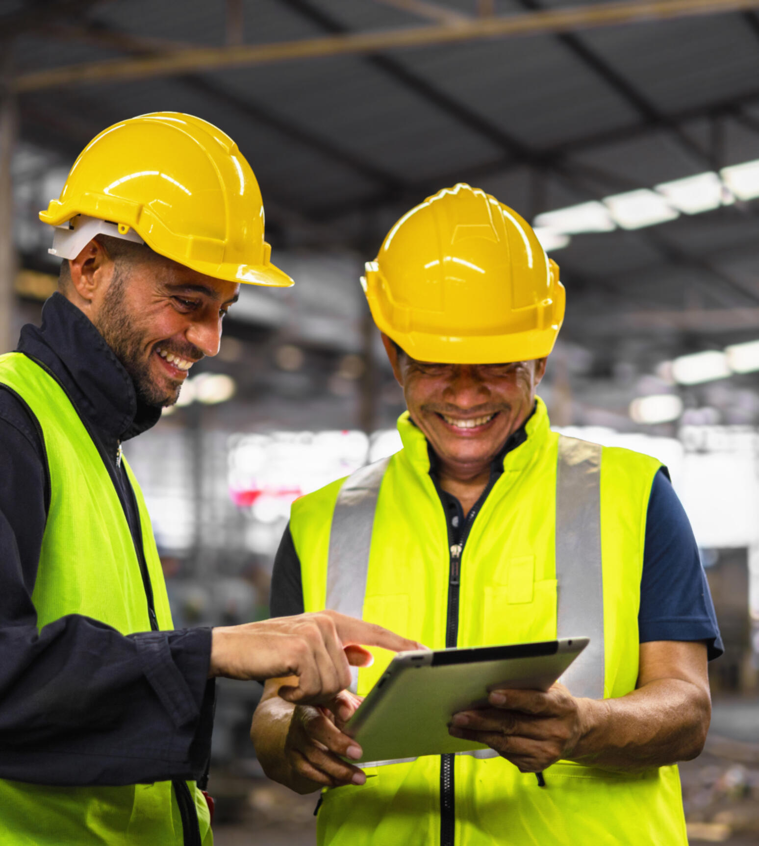 Two engineers with iPad wearing yellow hats