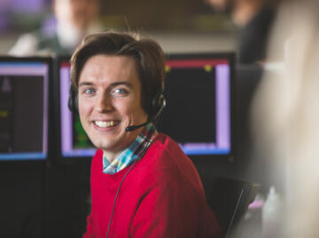 Contact centre operator wearing headset smiling at camera