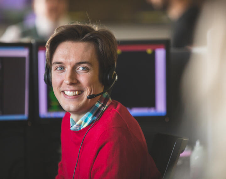 Contact centre operator wearing headset smiling at camera
