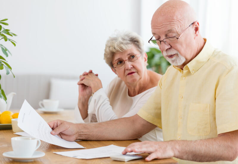 Elderly couple at a table discussing pensions
